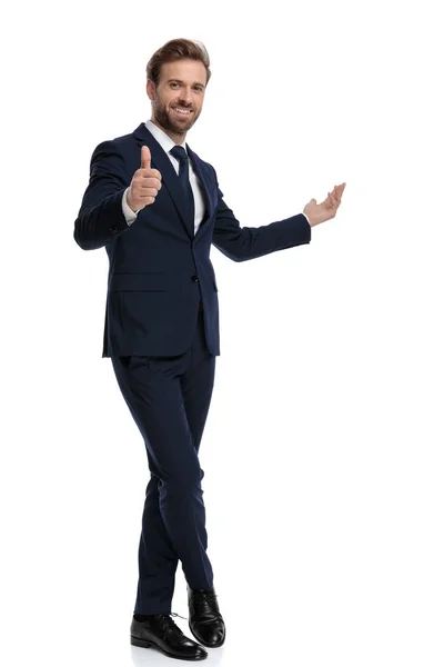 Happy businessman making thumbs up sign and presenting to side — 스톡 사진