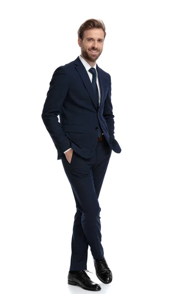 Happy businessman in navy blue suit holding hands in pockets — Stock Photo, Image