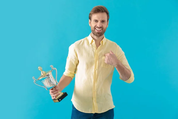 Homem casual feliz apontando para si mesmo e segurando troféu — Fotografia de Stock