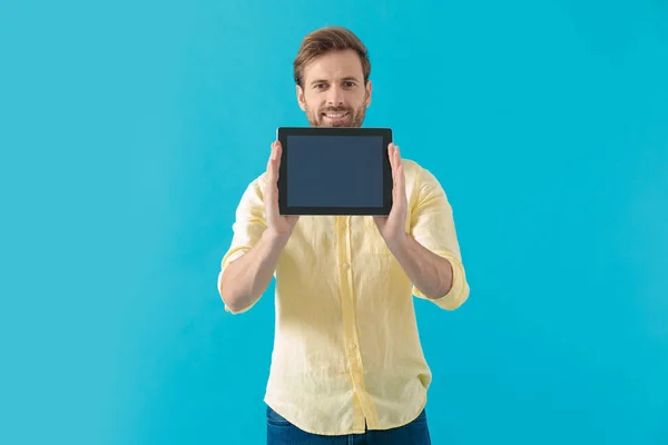 Positieve casual man tonen en presenteren van zijn tablet — Stockfoto