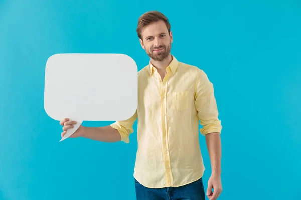 Positive casual man smiling and holding a speech bubble — 스톡 사진