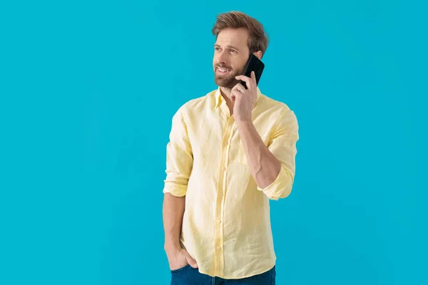 Esperanzado hombre casual hablando por su teléfono y mirando hacia otro lado —  Fotos de Stock