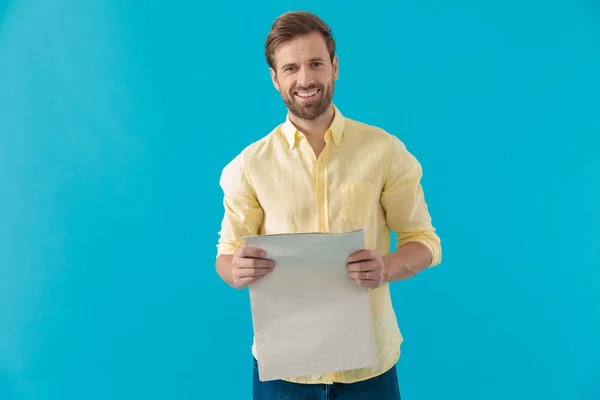 Cheerful casual man laughing and holding a newspaper — Stock Photo, Image
