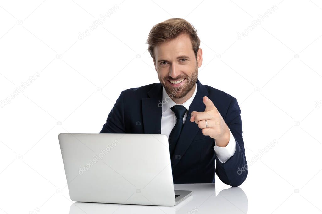 happy businessman in navy blue suit smiling and pointing finger