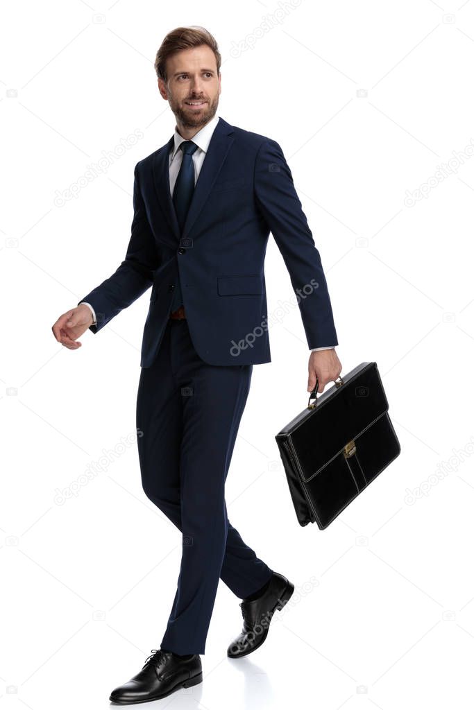 confident businessman in navy blue suit holding suitcase