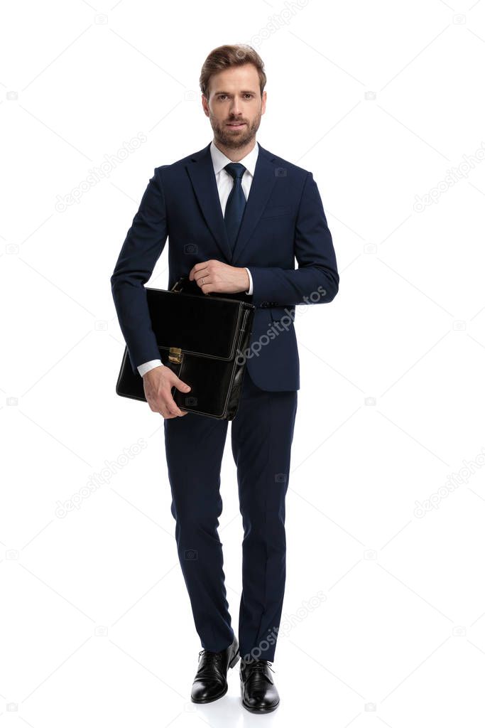 sexy young businessman in navy blue suit holding suitcase