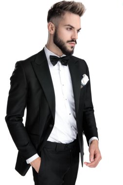 businessman standing with hand in pocket and looking away cool