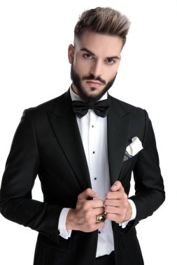 businessman standing and fixing jacket with cool attitude 