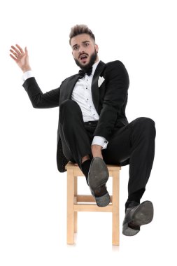 businessman sitting and leaning back while grabbing the chair sc