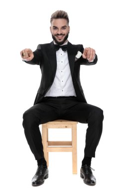 businessman sitting and pointing forward with both hands