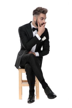 businessman sitting and touching face shocked while looking asid