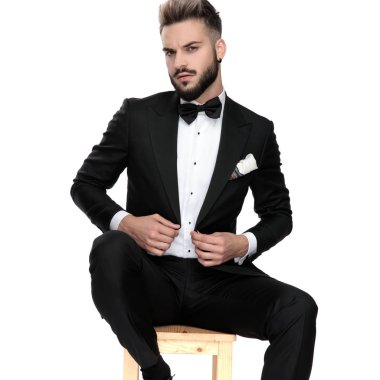 businessman sitting and fixing jacket with class