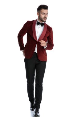sexy young model in red velvet tuxedo walking and looking to sid