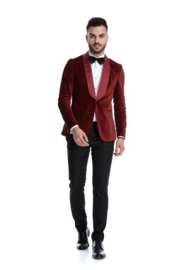 Kırmızı kadife smokinli seksi genç manken.