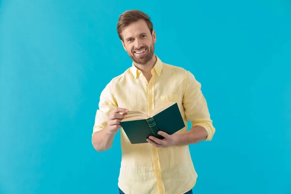 Hombre casual positivo sosteniendo un libro y riendo — Foto de Stock