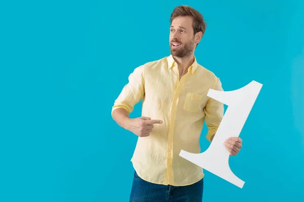 Hombre casual guapo señalando a un número uno y sonriendo — Foto de Stock