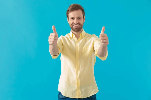 Positive casual man giving thumbs up and smiling — Stock Photo, Image
