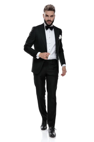 Businessman wearing black tuxedo walking with class — Stockfoto