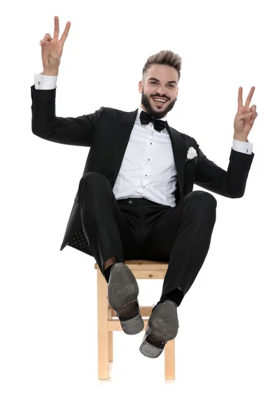 Businessman sitting and leaning back happy making victory sign — Stok fotoğraf