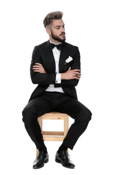 Geschäftsmann sitzt und schaut misstrauisch zur Seite — Stockfoto