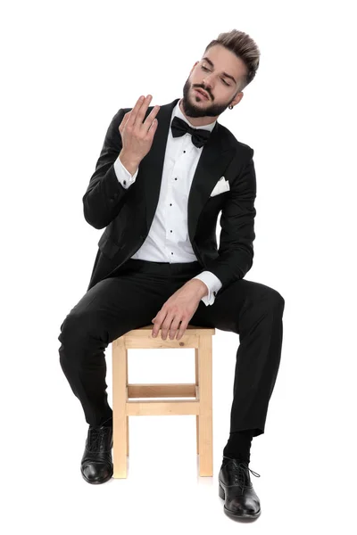Businessman sitting and checking his fingers — Stockfoto