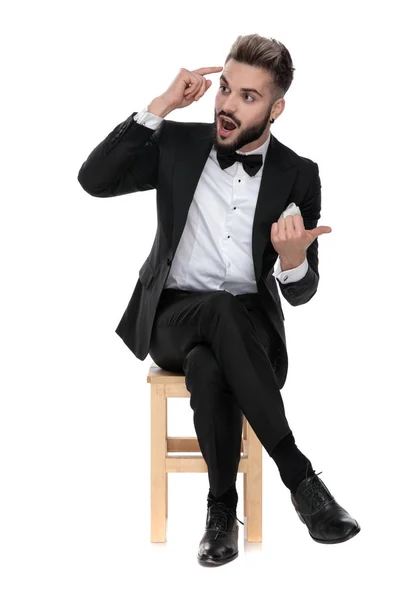 Empresário sentado e fazendo um sinal louco — Fotografia de Stock