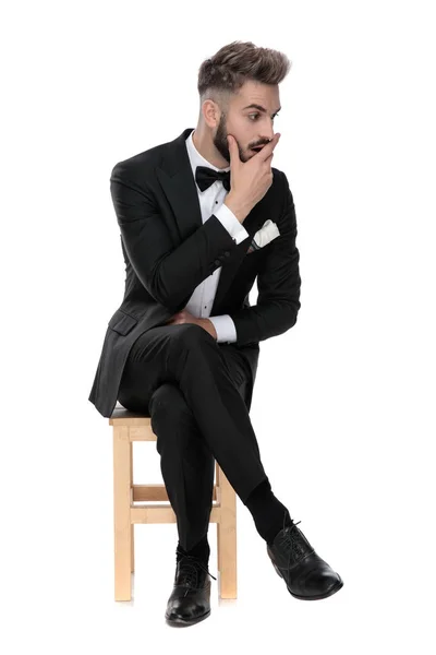 Biznesmen siedzi i dotyka twarzy zszokowany patrząc asid — Zdjęcie stockowe