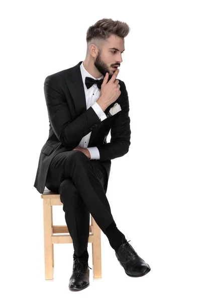 Businessman sitting and touching chin pensive — Stok fotoğraf