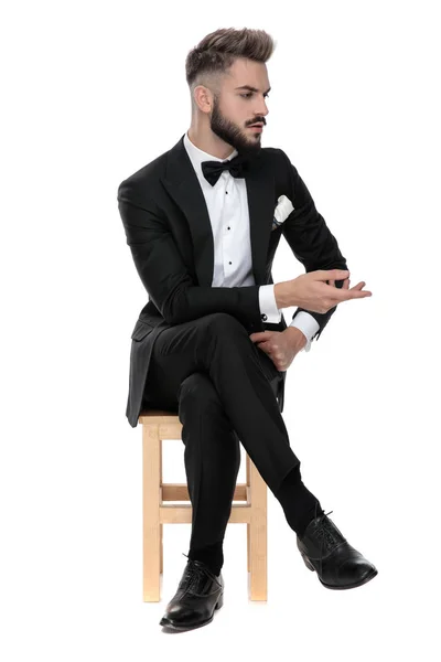 Hombre de negocios sentado y hablando con alguien a un lado — Foto de Stock