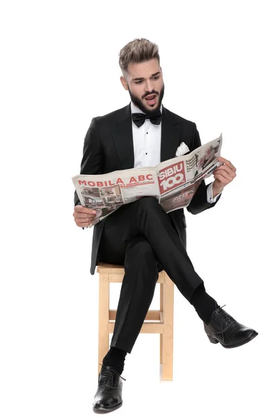 Businessman sitting and reading the newspaper shocked — Stock Photo, Image