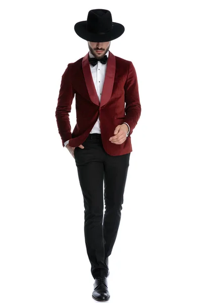 Fashion young man in red velvet tuxedo walking and looking down — 图库照片