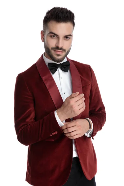 Sexy jovem homem no vermelho veludo smoking fixando camisa — Fotografia de Stock