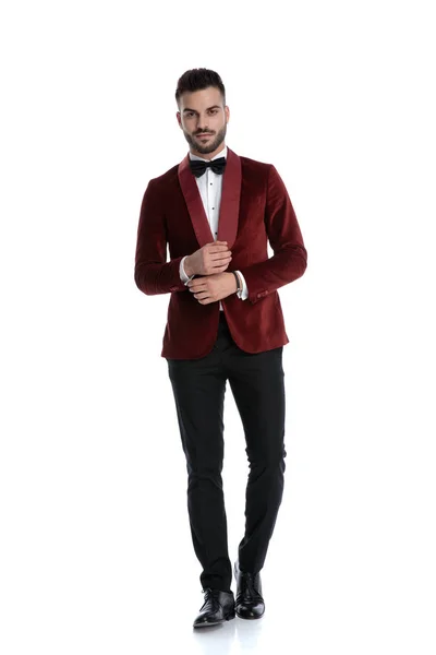 Cool fashion model in red velvet tuxedo touching hands — Stock Photo, Image