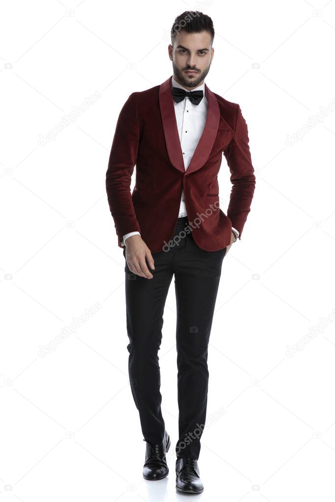 sexy young man in red velvet tuxedo holding hand in pocket