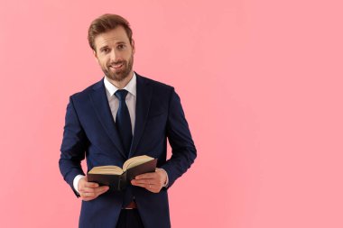 Neşeli iş adamı elinde bir kitap tutuyor ve dört gözle bekliyor.