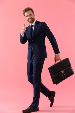 Pozitif iş adamı bir evrak çantası tutuyor ve onaylıyor.