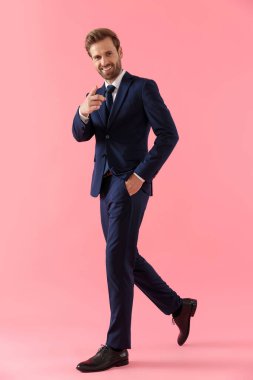 Neşeli işadamı işaret ediyor ve gülümsüyor