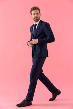 Pozitif iş adamı ceketinin düğmelerini açıp gülümsüyor. 