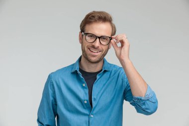Kendine güvenen genç model gülümsüyor ve gözlükleri tamir ediyor