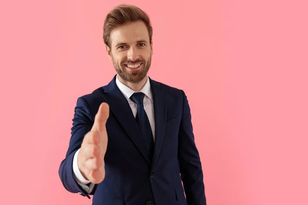 Positieve zakenman lachend en reikend naar een handdruk — Stockfoto