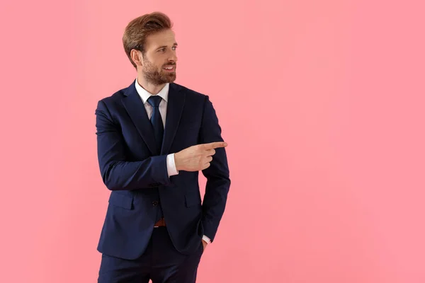 Hombre de negocios positivo sonriendo y señalando a un lado —  Fotos de Stock