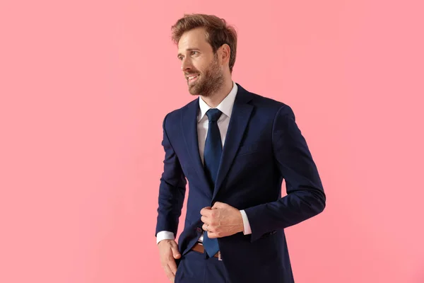 Empresário confiante ajustando seu casaco, desviando o olhar — Fotografia de Stock