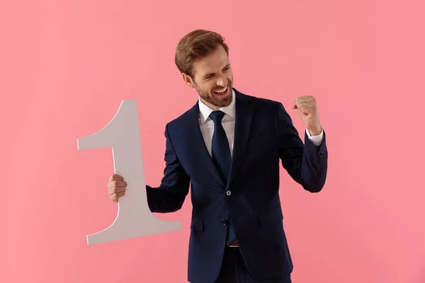 Positiver Geschäftsmann feiert mit Nummer eins und lacht — Stockfoto