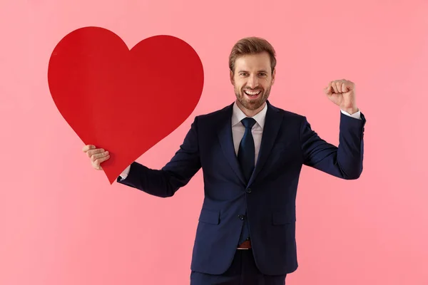 Cheerful businessman celebrating with a heart shape and laughing — Stock Photo, Image