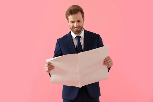 Empresário positivo lendo um jornal e sorrindo — Fotografia de Stock