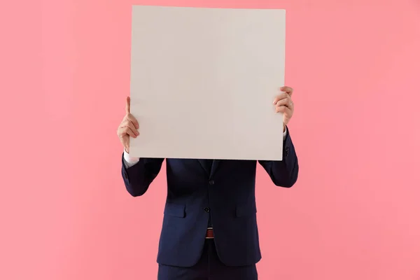 Junger Geschäftsmann verdeckt sein Gesicht mit einer leeren Plakatwand — Stockfoto