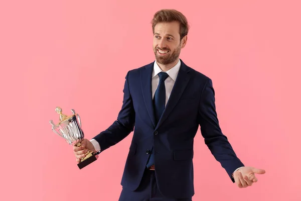 Proud businessman laughing and holding his trophy — Stock Photo, Image