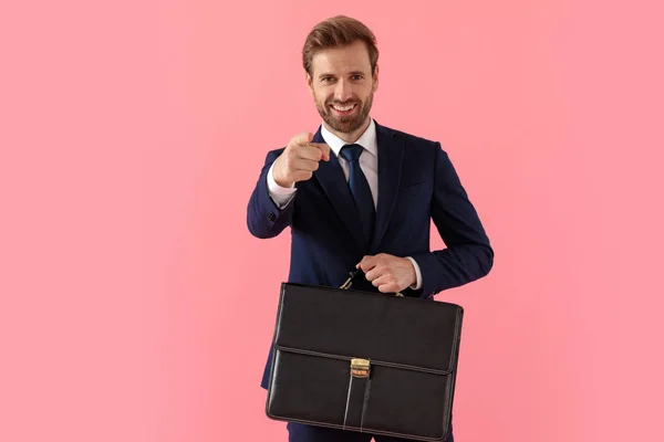 Веселий бізнесмен, який вказує вперед і тримає портфель — стокове фото