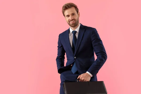 Позитивний бізнесмен тримає портфель посміхаючись — стокове фото