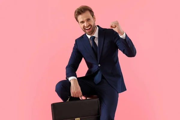 Uomo d'affari allegro che tiene una valigetta che celebra, gridando — Foto Stock